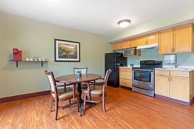 Modern kitchen area with dining table in a resident room