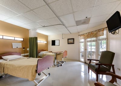 A bright resident room with two beds and a view