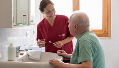 A caregiver assisting a resident in a bathroom