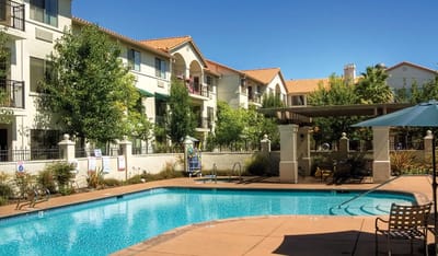 Outdoor pool area with residential building in background