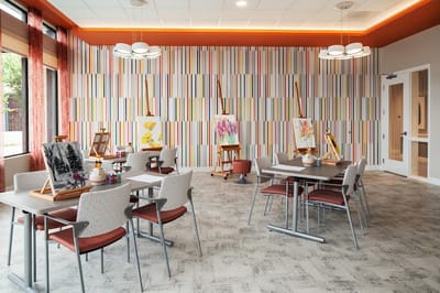 Bright art activity room with easels and tables