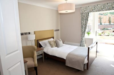 Bright, well-furnished resident room with garden view