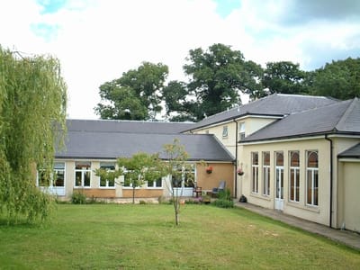 Exterior view of Oaklands House Care Centre with garden