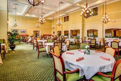Dining room setup with tables and chandeliers