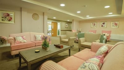 Cozy common area with pink sofas and floral decor