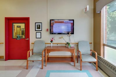 Interior area with seating, a table, and a wall-mounted screen