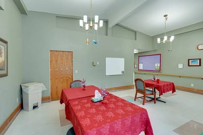 Dining room setup with red tablecloths and chairs