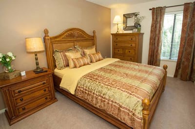 A well-decorated private resident room with a bed and furniture