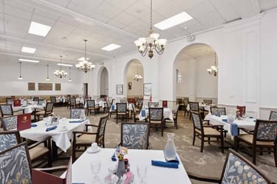 Well-furnished dining room with tables set for meals