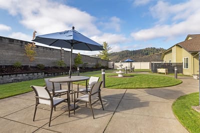 Outdoor seating area with umbrellas and green lawn