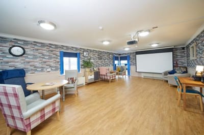 Bright common area with seating and projector screen