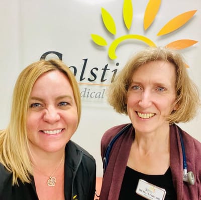 Two staff members smiling in a facility common area