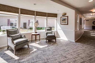 Bright common area with two armchairs and large windows