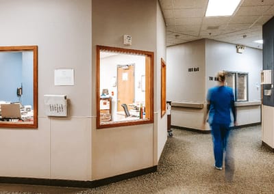 Healthcare staff member walking through a facility corridor