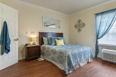 A cozy resident room with a well-made bed