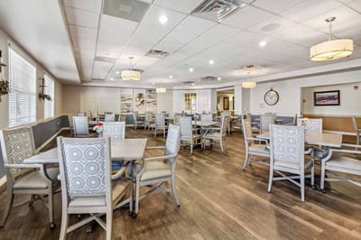 Dining area with tables and chairs in a sunny room