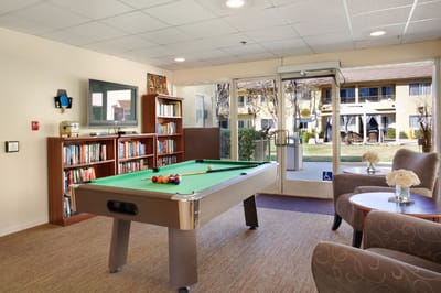 Common area with a pool table and bookshelves