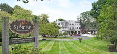 Exterior view of Sunrise Senior Living facility with sign.
