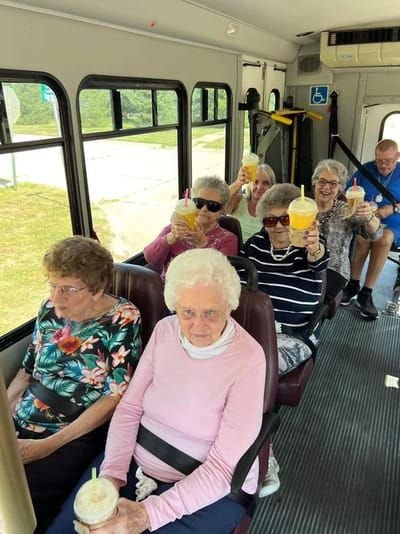 Residents enjoying drinks on the facility transport bus