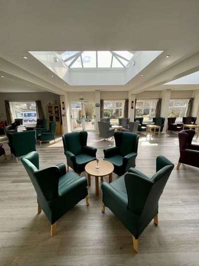 Interior view of a bright common area with chairs and tables