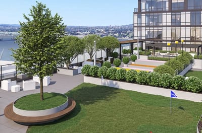 Patio area with seating and greenery on a building rooftop