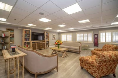 Bright common area with comfortable seating and shelves