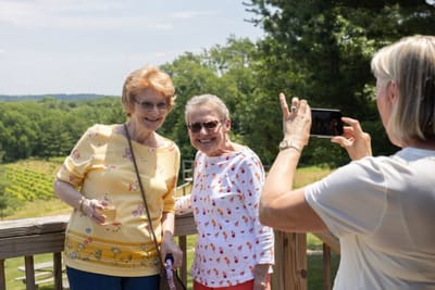 Two residents posing together outdoors with a scenic background