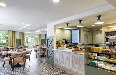 Bright dining area with a display of pastries