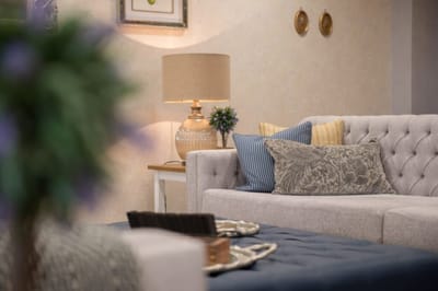 A cozy interior of a living space with a sofa and lamp.