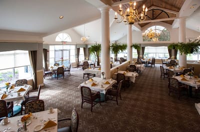 Bright dining room with tables set for residents