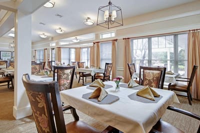 Dining area with neatly set tables and floral decor
