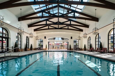 Indoor swimming pool area with skylights and seating