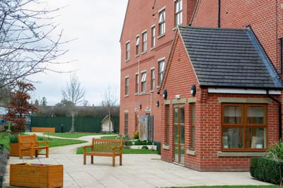 Exterior view of a care facility with outdoor seating