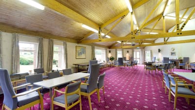 Bright common area with tables and chairs for residents