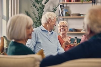 Seniors engaging in cheerful conversation in a common area.