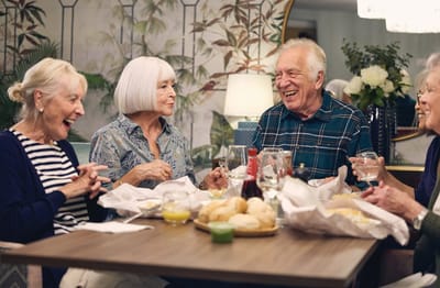 Residents enjoying a meal and conversation together.