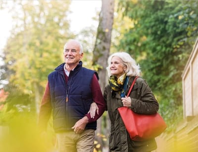 Elderly couple walking together outdoors.