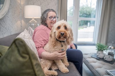 Resident enjoying time with a dog in a common area.