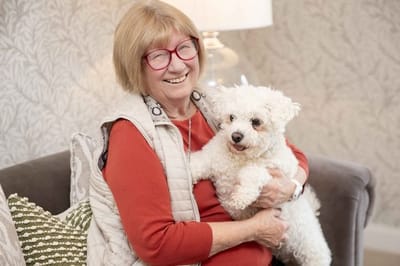 Smiling resident holding a small dog