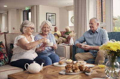 Residents enjoying tea and snacks in a common area.