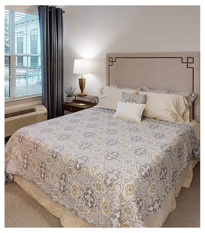 Cozy bedroom setup with decorative bedding and lamp