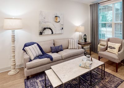 A cozy living room area with a couch and lamp