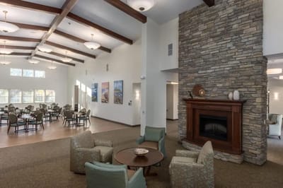 Bright common area with seating and stone fireplace