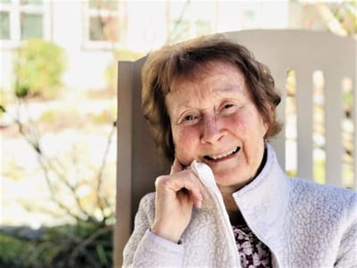 Smiling resident sitting outdoors, enjoying the sun
