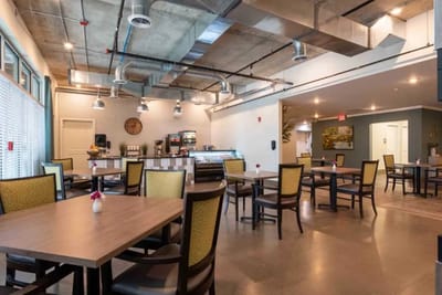 Bright dining room with tables and chairs set up