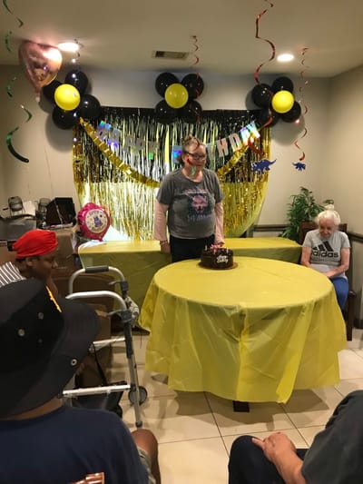 Residents celebrating a birthday in a decorated common area