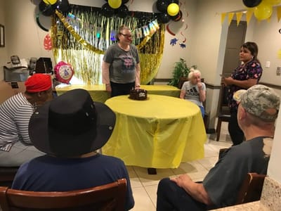 Residents celebrating with a cake in a festive room