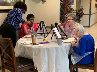 Residents painting in a common area activity