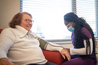 A caregiver taking a resident's blood pressure