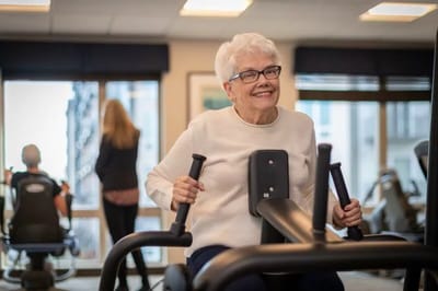 A senior woman using exercise equipment in a fitness area